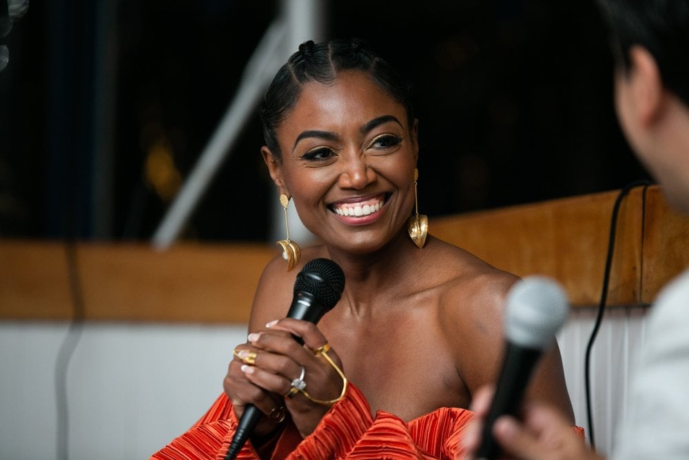 Patina Miller smiling with microphone in hand